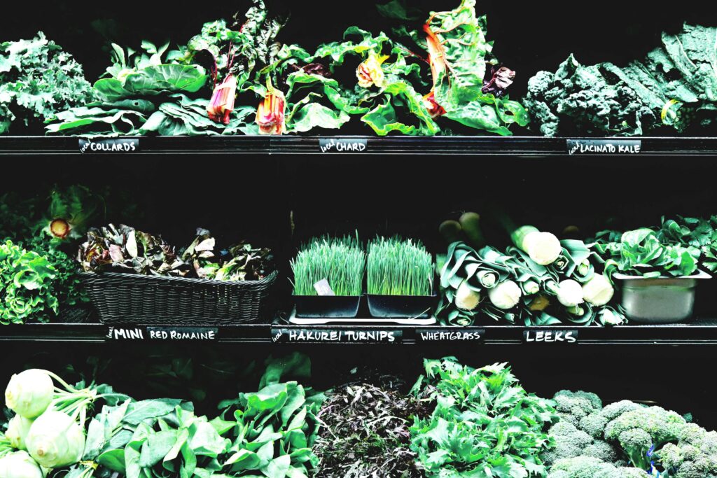 Vibrant display of fresh organic greens and vegetables in a market setting.