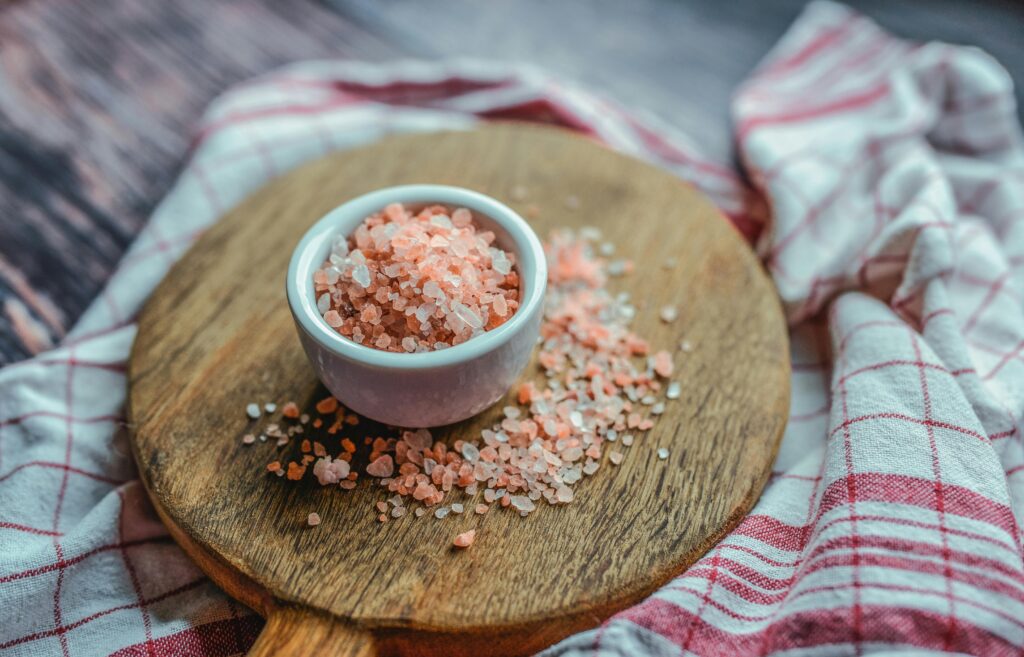 pexels-photo-2624400-2624400 A close-up shot of pink Himalayan salt in a ceramic cup on a wooden board. Ideal for culinary and health visuals.